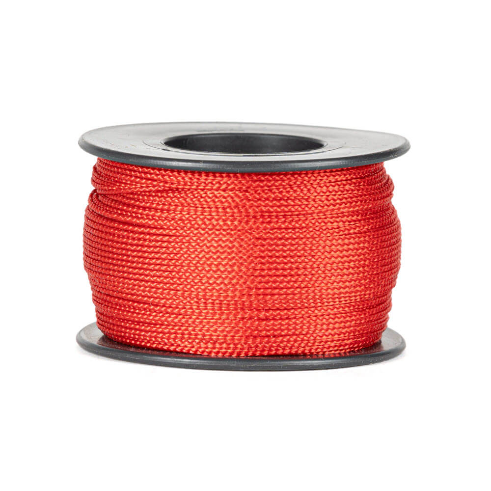 Une bobine de 90 mètres de corde polyester rouge de 0,8 mm d’épaisseur, tressée de manière serrée et uniforme, soigneusement enroulée sur une bobine noire avec des flasques rondes en haut et en bas, sur un fond blanc.
