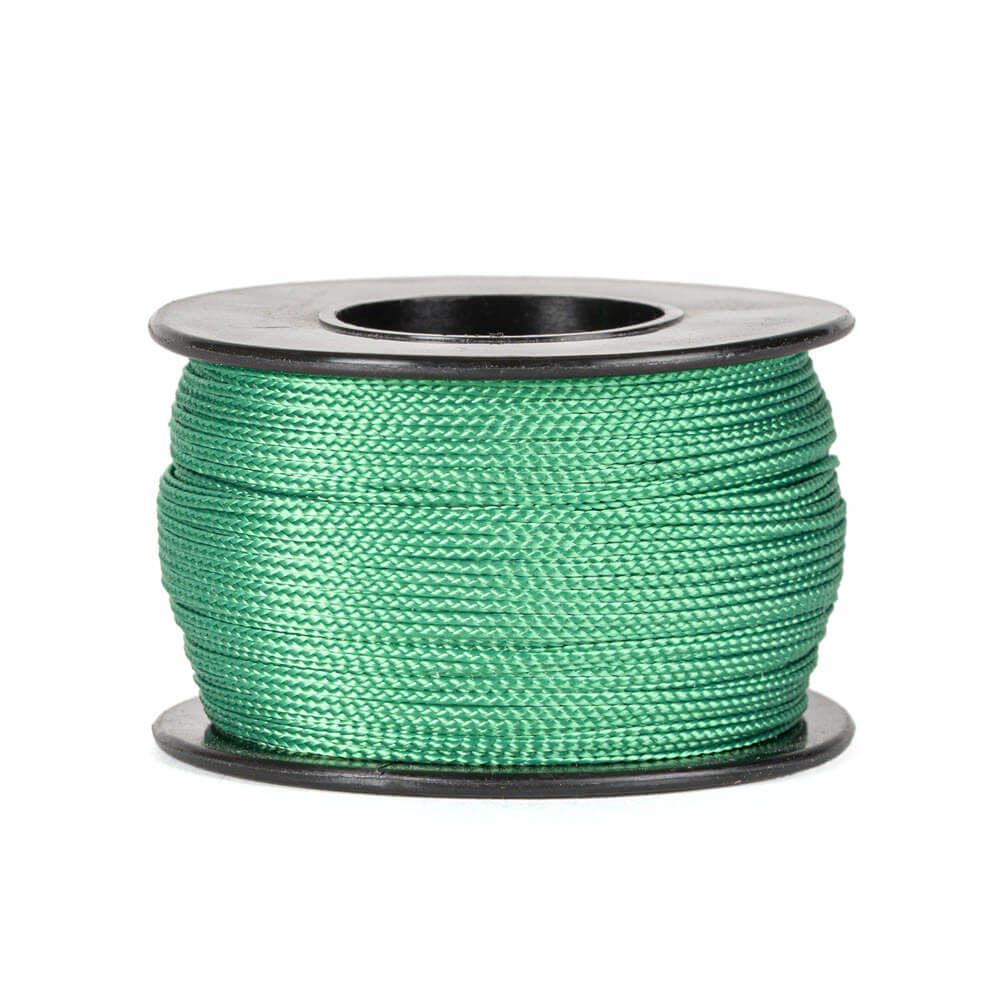 Une bobine de 90 mètres de corde polyester verte de 0,8 mm d’épaisseur, tressée de manière serrée et uniforme, soigneusement enroulée sur une bobine noire avec des flasques rondes en haut et en bas, sur un fond blanc.