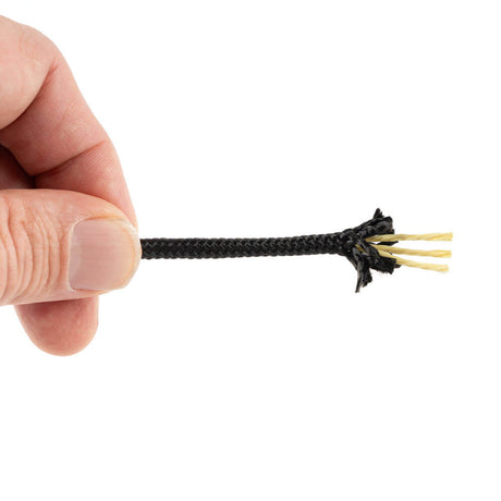 Une main tient un cordon Kevlar de 4 mm avec une gaine en polyester noir. L'extrémité du cordon est effilochée, révélant les trois brins jaunes de Kevlar de l'âme, sur un fond blanc.
